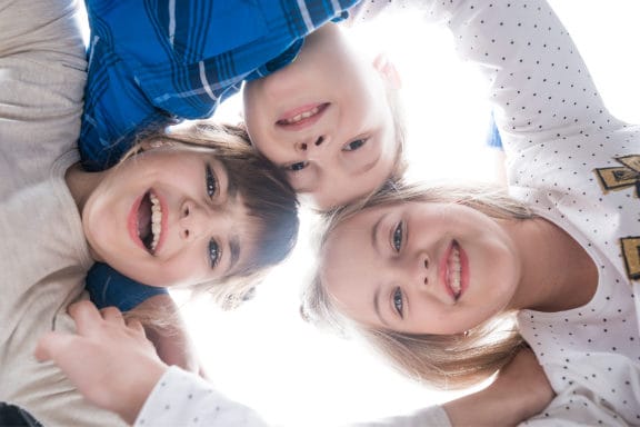 Children in a circle with their hands on each others shoulders