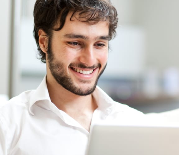 Man sitting on couch looking down at his laptop