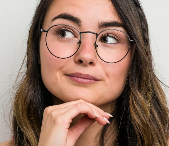 Woman holding her hand below her chin and thinking