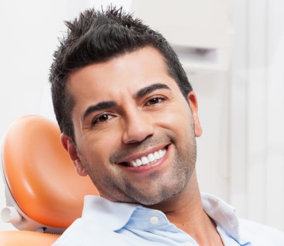 Man sitting in dental chair and smiling