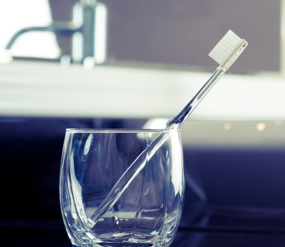 Toothbrush standing up inside a glass