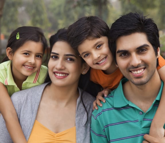 Family of four holding each other and smiling