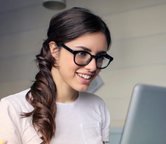 Woman looking down at her computer at her desk