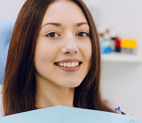 Woman sitting in dental chair smiling